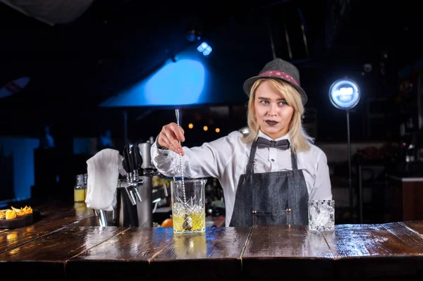 Девушка-бармен смешивает коктейль в кафе — стоковое фото