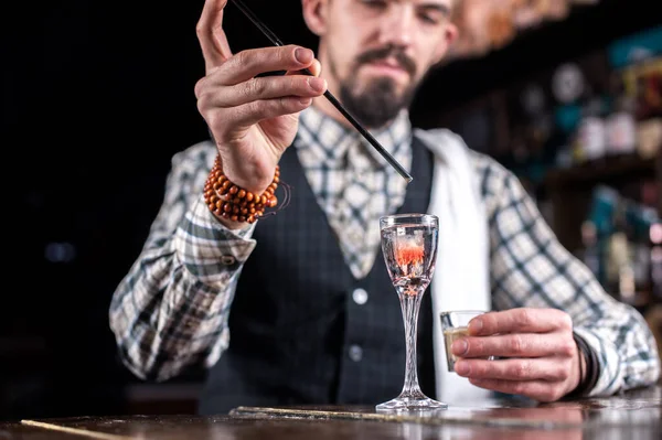 Bartendern kokar ihop en cocktail på saloonen — Stockfoto