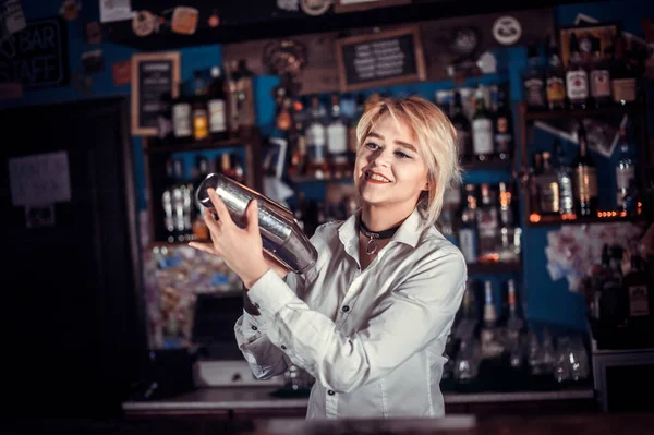 Pretty barmaid decorates colorful concoction in the night club — Stock Photo, Image