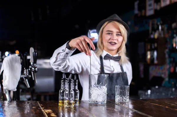 Charmig flicka bartender gör en show som skapar en cocktail bakom bar — Stockfoto