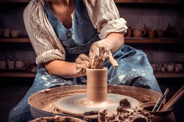 Handen van de pottenbakker en vaas van klei op het pottenbakkerswiel close-up. Meester Crock. Verdraaid pottenbakkerswiel. — Stockfoto