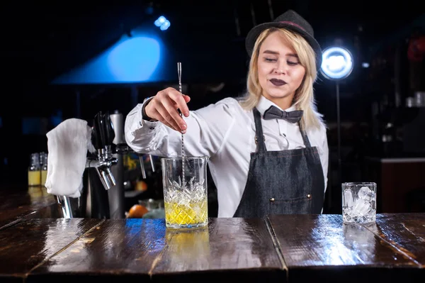 Flickbartendern kokar ihop en cocktail på ölhallen — Stockfoto