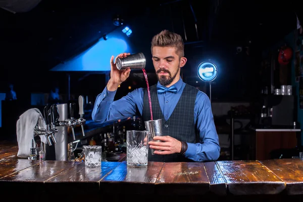 Charmante barkeeper rondt zijn creatie intens af in de pub — Stockfoto