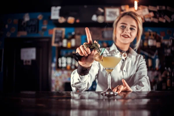 Chica barman profesional demuestra sus habilidades profesionales mientras está de pie cerca del mostrador de bar en el bar —  Fotos de Stock