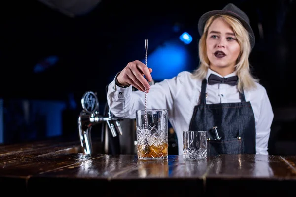 Deneyimli kadın tapster bardaki bir kokteyle malzeme ekler. — Stok fotoğraf