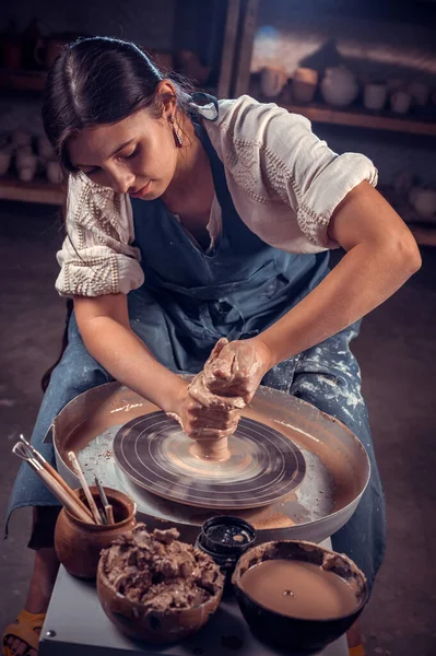 Elegante escultor alfarero profesional trabaja con arcilla en una rueda Potters y en la mesa con las herramientas. Trabajo a mano. — Foto de Stock