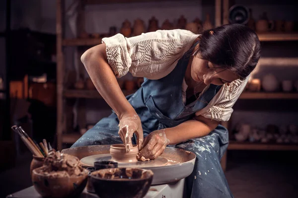 Hands of the master potter and vase of clay on the potters wheel close-up. Master crock. Twisted potters wheel. — Stock Photo, Image