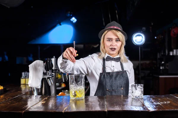 Karismatisk kvinna bartender gör en show som skapar en cocktail i baren — Stockfoto
