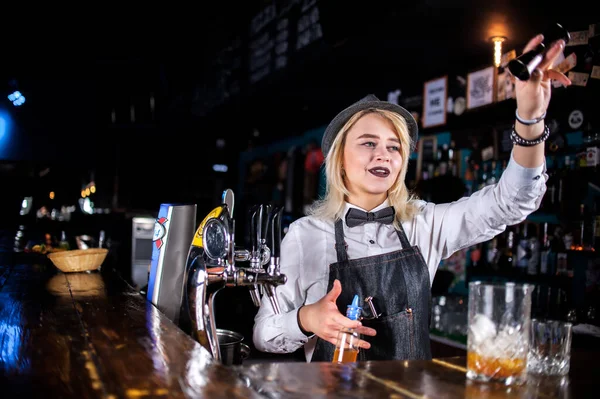 Charmig flicka bartender skapar en cocktail vid bardisken — Stockfoto