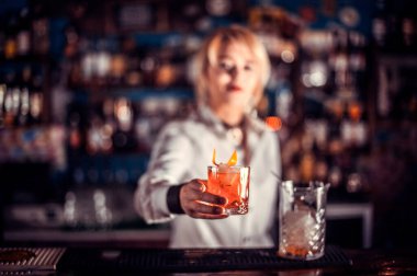 Kız barmen barda kokteyl hazırlıyor.