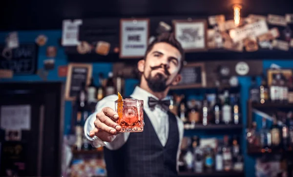 Ung bartender tillför ingredienser till en cocktail på nattklubben — Stockfoto