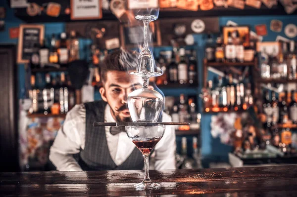 Barman barbudo derramando bebida alcoólica fresca nos óculos no bar — Fotografia de Stock