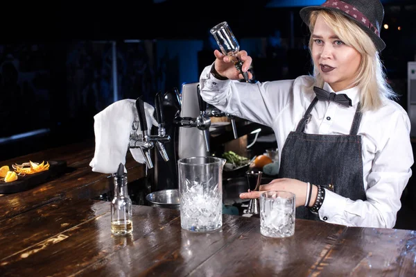 Fokuserad kvinna bartender formulerar en cocktail på baren — Stockfoto