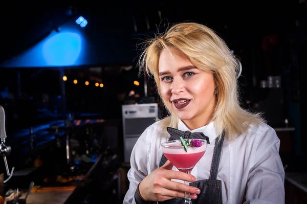 Självsäker flicka bartender blandar en cocktail när du står nära bardisken i puben — Stockfoto