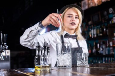 Kız barmen barda kokteyl hazırlıyor.