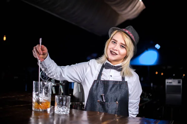 Flicka bartender skapar en cocktail i salongen — Stockfoto