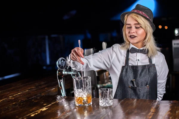 Flicka bartender blandar en cocktail på saloonen — Stockfoto