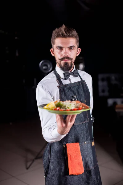 Professionell vänlig servitör erbjuder besökarna aptitretande maträtt på en festlig händelse. — Stockfoto