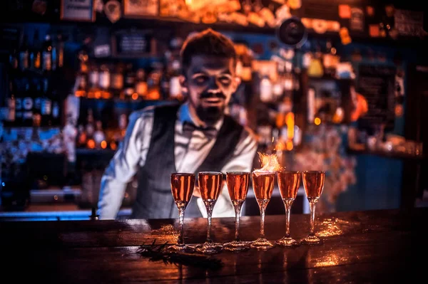 Bearded bartending demonstrates the process of making a cocktail behind the bar — Stock Photo, Image