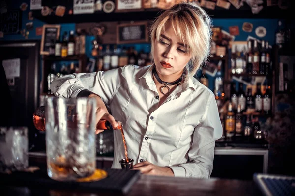 Fokuserad kvinna bartender gör en cocktail vid bardisken — Stockfoto