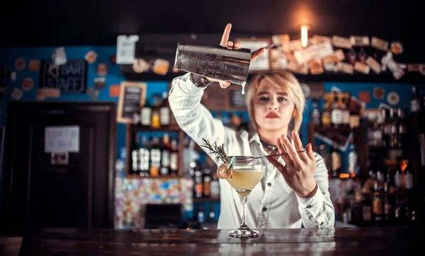 Charismatique fille barman formule un cocktail tout en se tenant près du comptoir du bar dans le pub — Photo