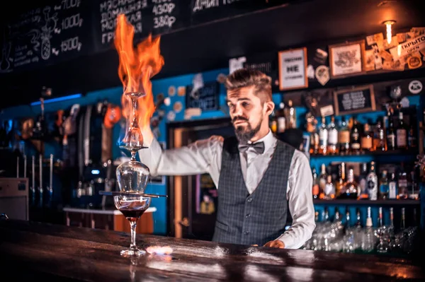 Bartender kokar ihop en cocktail bakom baren. — Stockfoto