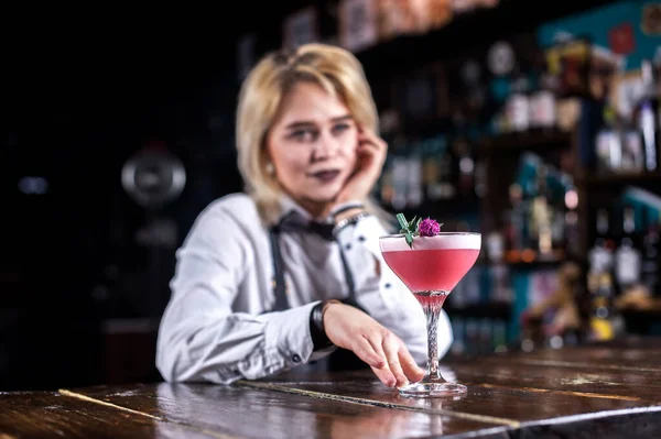 Joven barman chica demuestra sus habilidades profesionales, mientras que de pie cerca de la barra de bar en el bar —  Fotos de Stock