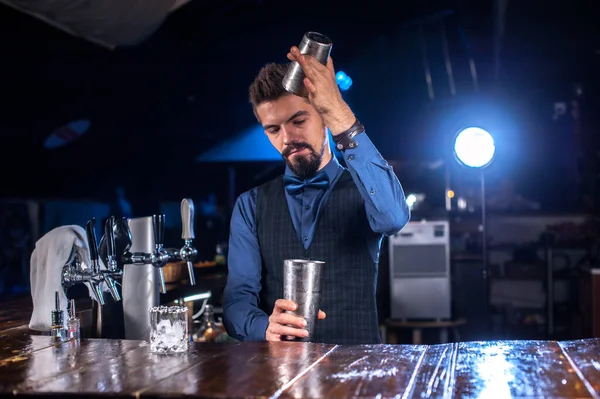 Ung tapster tillför ingredienser till en cocktail i baren — Stockfoto