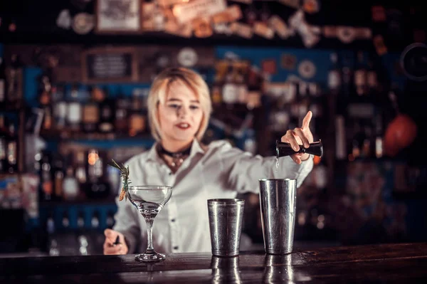 Flicka bartender gör en cocktail bakom baren — Stockfoto