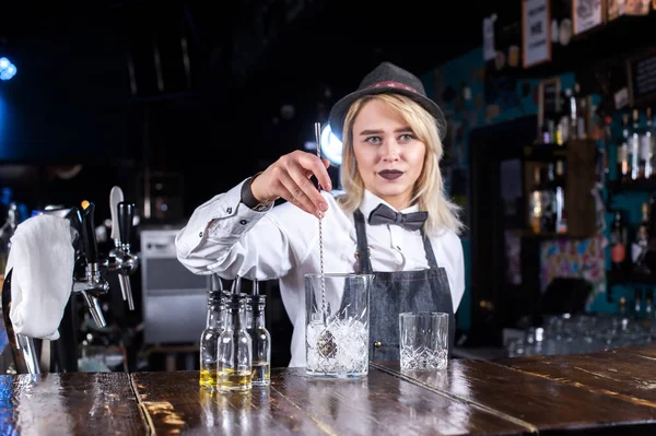 Självsäker kvinna bartender visar processen att göra en cocktail när du står nära bardisken i puben — Stockfoto