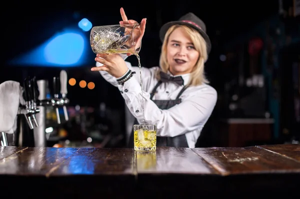 Zkušená barmanka vytvoří koktejl za barem — Stock fotografie