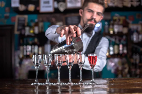 Mladý barman demonstruje proces výroby koktejlu v nočním klubu — Stock fotografie