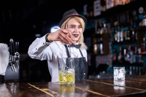 Молодая барменша устраивает шоу, создавая коктейли в коктейльных барах — стоковое фото