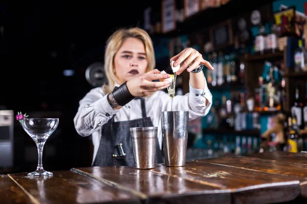 Söt flicka bartender gör en cocktail när du står nära bardisken i nattklubb — Stockfoto