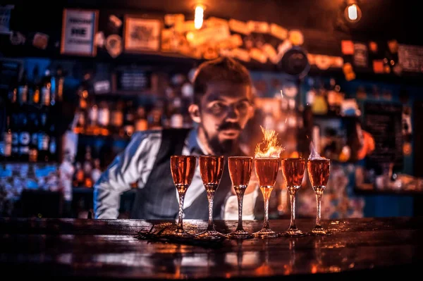 Experienced bartending pouring fresh alcoholic drink into the glasses in the bar — Stock Photo, Image