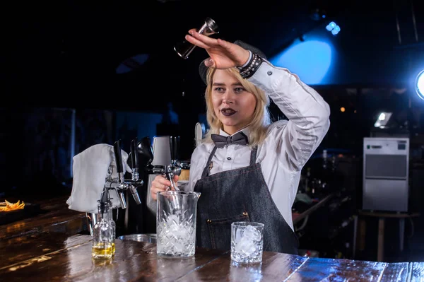 Hezká dívka barman intenzivně dokončí svůj výtvor, zatímco stojí v blízkosti baru v baru — Stock fotografie