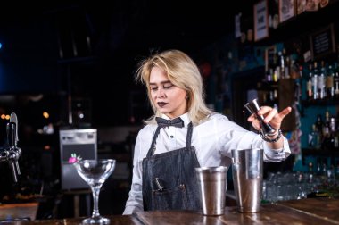 Kız barmen banyoda bir kokteyl hazırlıyor.