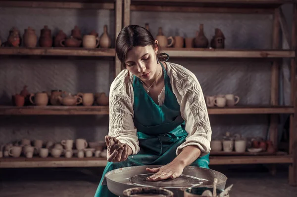 Mooie keramist meester werkt met klei op een pottenbakkerswiel. Ambachten. — Stockfoto