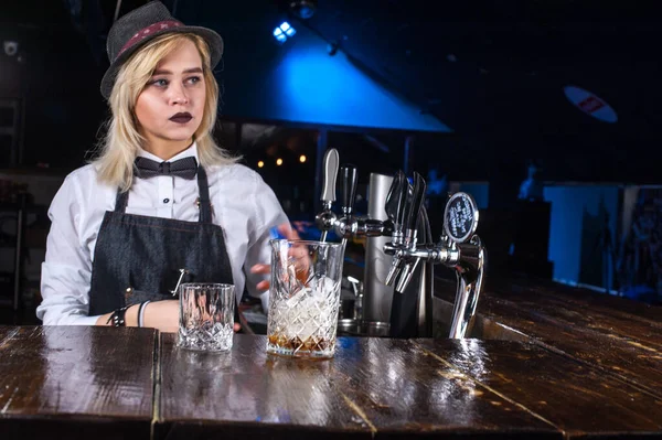 Charismatická dívka barman umístí dokončovací doteky na nápoj v hospodě — Stock fotografie