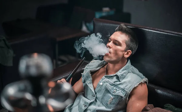 Avrupalı görünümlü bir adam nargile barında sigara soluyor.. — Stok fotoğraf