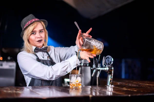 Karismatisk kvinna bartending tillför ingredienser till en cocktail i puben — Stockfoto