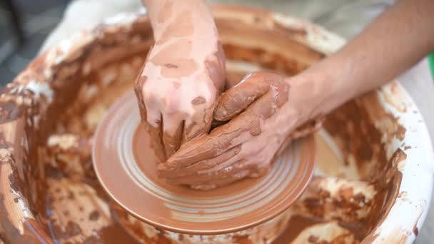 Création d'un vase d'argile blanche en gros plan. Le sculpteur de l'atelier fabrique une cruche en terre cuite. Roue de potiers torsadés. Maître crock. — Video