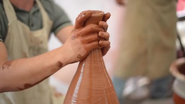 Гончар своїми руками формує довгу шию глиняного глечика — стокове відео