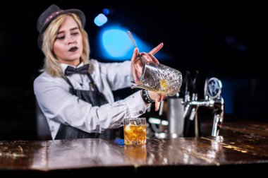 Karizmatik barmen kız barda kokteyl hazırlar.