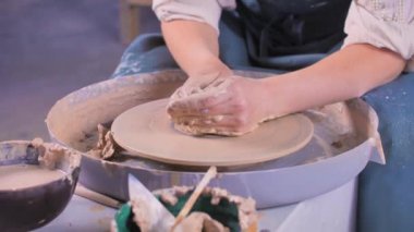 Çömlekçi çarkında çalışan kadın usta. Elleriyle çiğ kil kullanıyor. Sanat yaratıcılığı kavramı. Yakın plan..