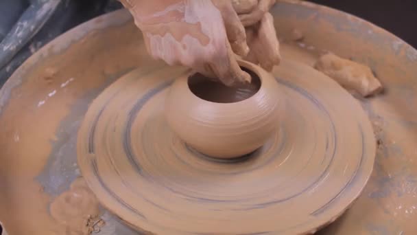Handen van de pottenbakker en vaas van klei op het pottenbakkerswiel close-up. Meester Crock. Verdraaid pottenbakkerswiel. — Stockvideo