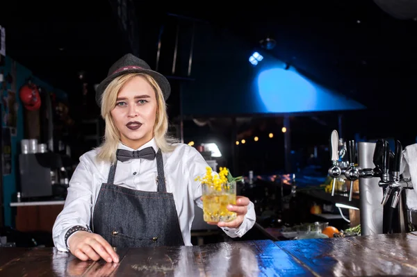 Profesionální dívka barman umístí dokončovací doteky na drink za barem — Stock fotografie