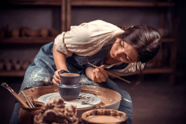 Piękna młoda kobieta mistrz demonstruje proces produkcji naczyń ceramicznych przy użyciu starej technologii. Ludowe rzemiosło. — Zdjęcie stockowe