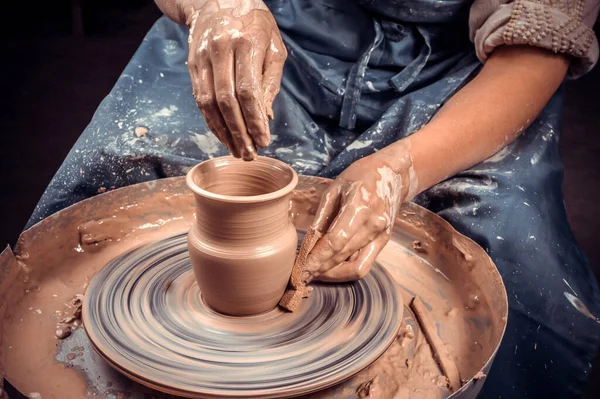 O mestre-ceramista cria um pote de barro em uma roda de oleiros. Mãos de oleiro de perto. Artesanato antigo e trabalho artesanal de cerâmica — Fotografia de Stock