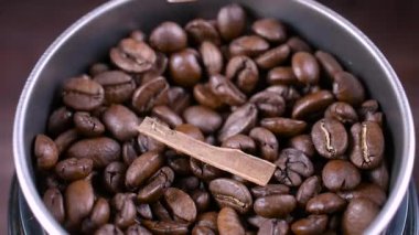 Kahve öğütücüsünde kahve çekirdekleri. Tarçın çubuğuyla kahve öğütüyorum..